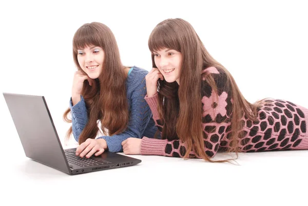 ノート パソコンで 2 つの双子姉妹の肖像 — ストック写真