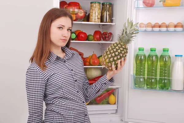 Молодая девушка у холодильника со здоровой едой . — стоковое фото