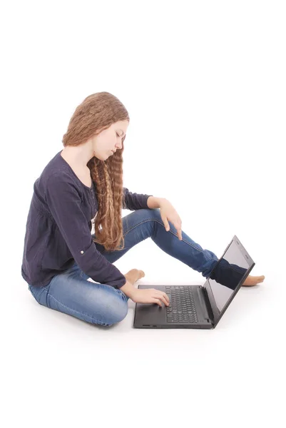 Schülerin sitzt mit Laptop seitlich auf dem Boden — Stockfoto