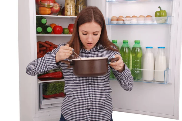 Bella mujer degustación de alimentos en el fondo del refrigerador — Foto de Stock