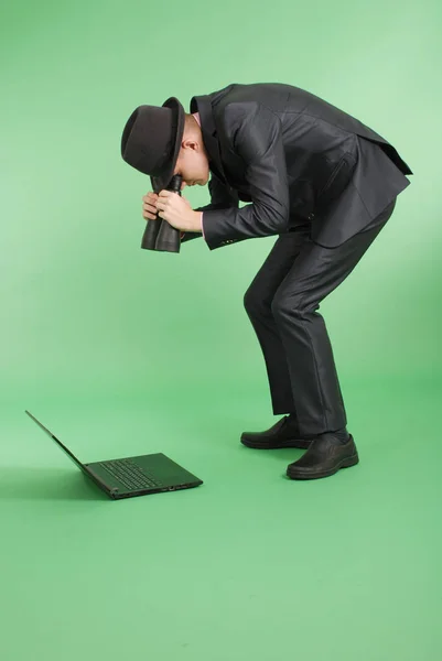 Man in a black suit with a laptop — Stock Photo, Image