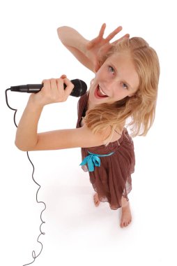 Mutlu genç güzel kız mikrofon ile şarkı