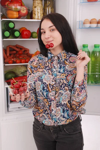 Молодая девушка у холодильника со здоровой едой . — стоковое фото