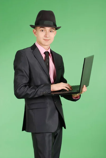 Homem de terno preto com um laptop — Fotografia de Stock