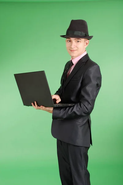 Людина в чорному костюмі з ноутбуком — стокове фото
