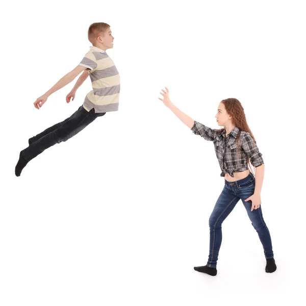 Flickan håller pojken i kommer i luften. Levitation med tankens kraft. — Stockfoto