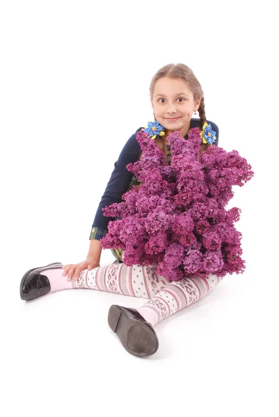 Atraktivní dívka, sedící na podlaze bílý s lila v ruce — Stock fotografie