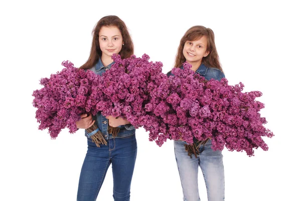 Dos chicas adolescente de pie con lila en las manos — Foto de Stock