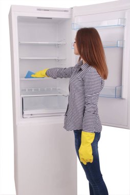 Genç kız bir sünger ile boş buzdolabı temizlik.