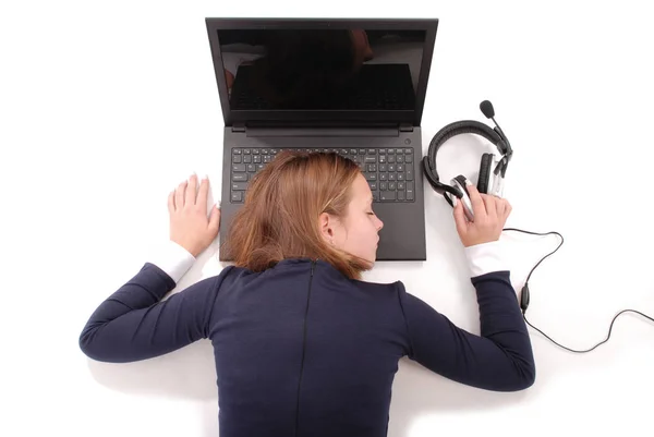 Imagem de bonito menina dormindo encontra-se perto de computador portátil em fones de ouvido — Fotografia de Stock