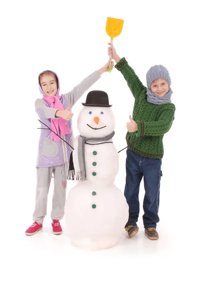 Lindo chico y chica con muñeco de nieve con bufanda y sombrero — Foto de Stock