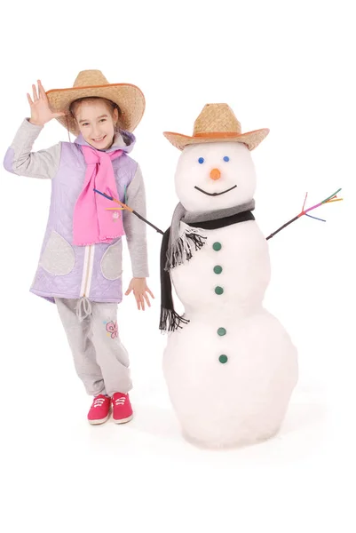 Linda chica con muñeco de nieve con bufanda y sombrero — Foto de Stock