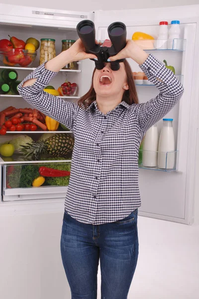 Hermosa joven cerca del refrigerador con comida saludable . — Foto de Stock