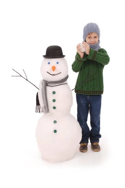 Rapaz bonito com boneco de neve com cachecol e chapéu — Fotografia de Stock