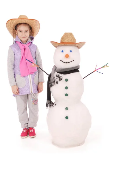 Linda chica con muñeco de nieve con bufanda y sombrero — Foto de Stock