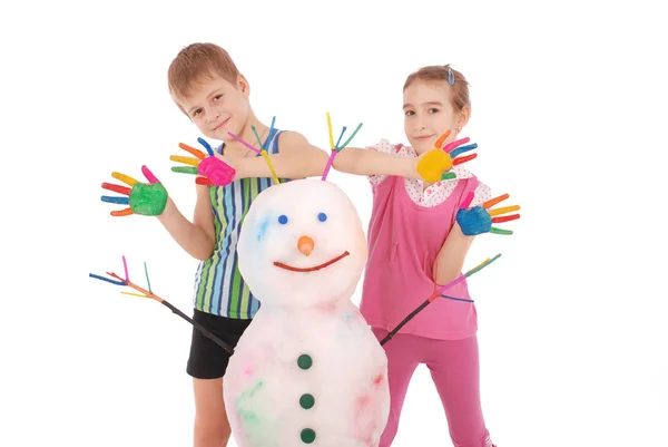 美しい少年とペイント色の角と手で色の雪だるまの近くに手を持つ少女 — ストック写真