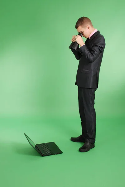 Man in a black suit with a laptop — Stock Photo, Image