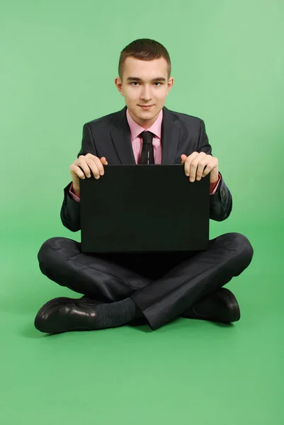 Man in a black suit with a laptop — Stock Photo, Image