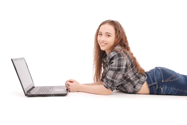 Молода дівчина лежить і використовує ноутбук — стокове фото