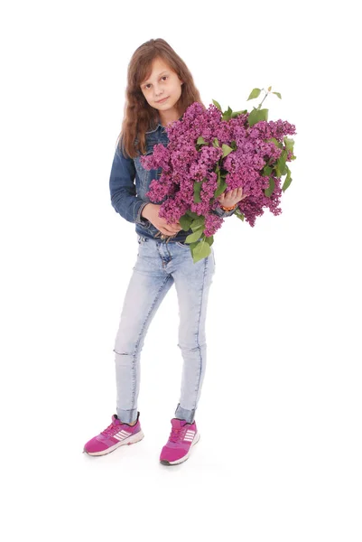 Chica adolescente de pie con lila en las manos — Foto de Stock