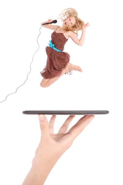 Chica joven saltar y cantar con micrófono usando tableta pc en la mano de la gente —  Fotos de Stock
