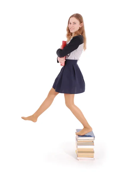 Education, people, teenager and school concept - teenager school girl standing on stack of books — Stock Photo, Image