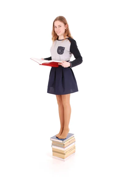 Bildung, Menschen, Teenager und Schulkonzept - Teenager-Schülerin steht auf Bücherstapel — Stockfoto