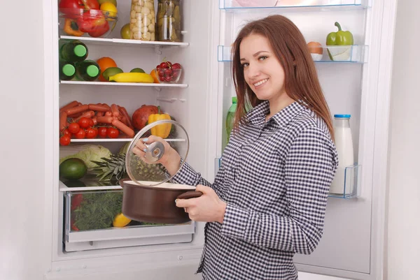 Tevreden huisvrouw in de buurt van gevulde koelkast. — Stockfoto