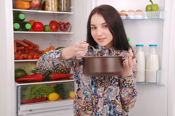 Mulher bonita Degustação de alimentos no fundo da geladeira — Fotografia de Stock