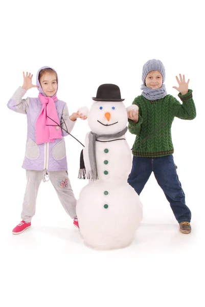 Lindo chico y chica con muñeco de nieve con bufanda y sombrero — Foto de Stock