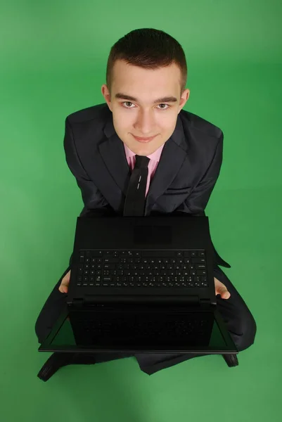 Homem de terno preto com um laptop — Fotografia de Stock