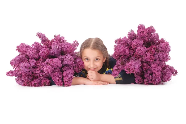 Atraktivní dívka leží na bílé podlaze s lila v ruce — Stock fotografie