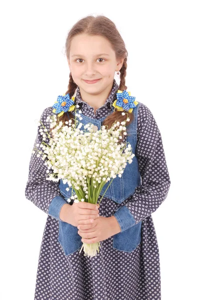Retrato de una linda niña feliz sostiene una flor de un lirio del valle . — Foto de Stock