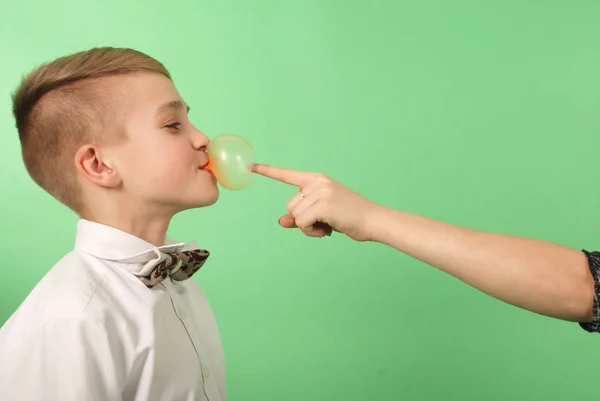 Young boy stretching from chewing gum which he carries in his mouth — Stock Photo, Image