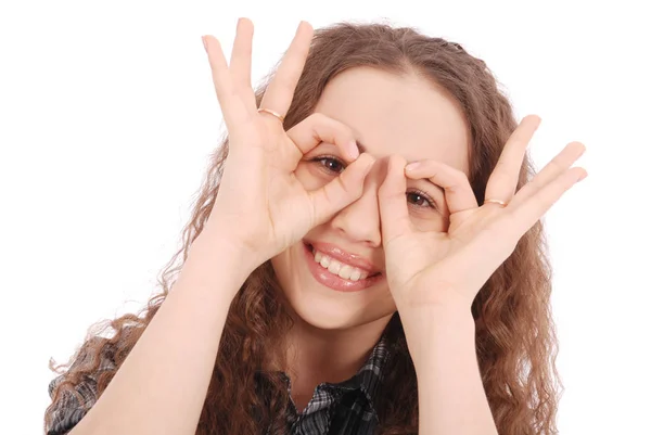 Retrato de una chica joven y divertida mirando la cámara a través de los dedos — Foto de Stock