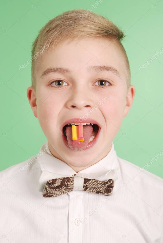 Young boy put the chewing gum on his tongue 