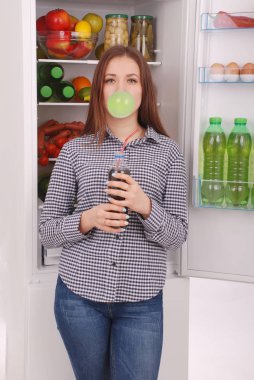 Cola tutarak ve bir sakız ile büyük bir kabarcık yapma genç kız