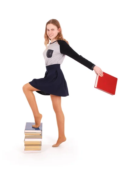 Onderwijs, school, mensen en tiener concept - tiener school meisje staan op stapel boeken — Stockfoto