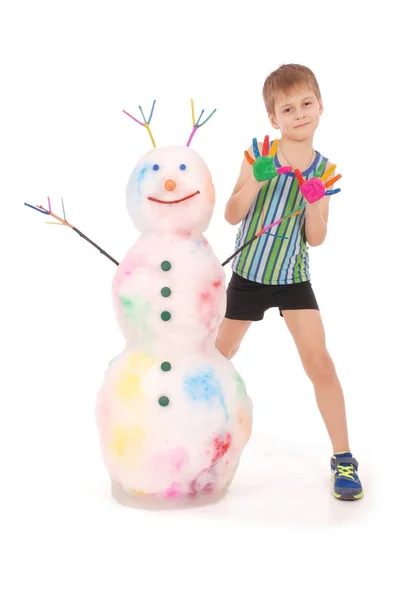 Bellissimo ragazzo con le mani in vernice vicino al colore pupazzo di neve con corna e mani colorate — Foto Stock