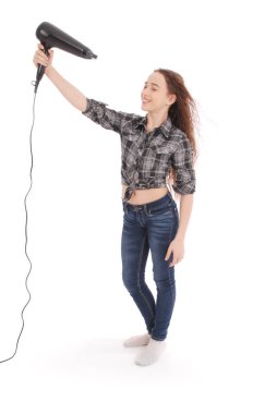 Saç kurutma makinesi kullanan genç kız