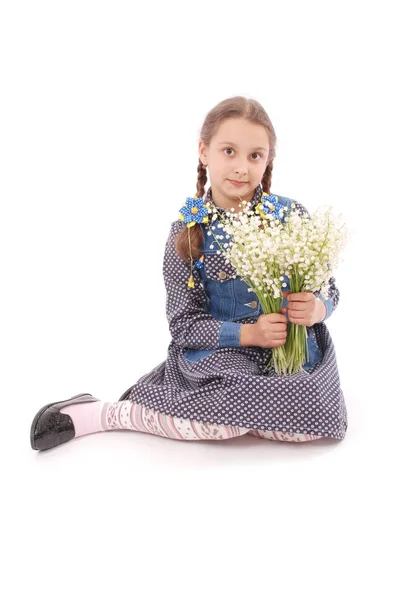 Retrato de una linda niña feliz sostiene una flor de un lirio del valle . — Foto de Stock