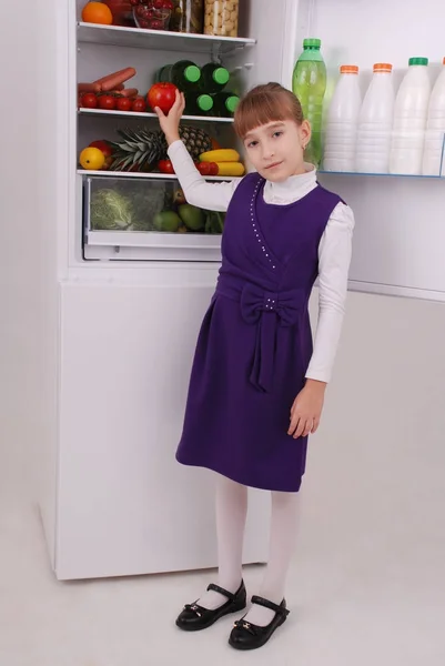 Belle fille près du réfrigérateur avec des aliments sains . — Photo