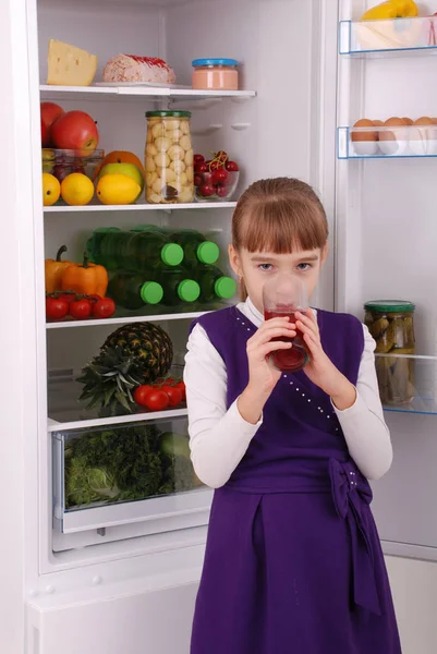 Hermosa chica cerca del refrigerador con comida saludable . — Foto de Stock