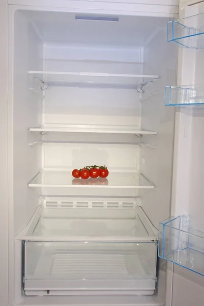Cherry rajčata otevřené prázdné ledničky. — Stock fotografie
