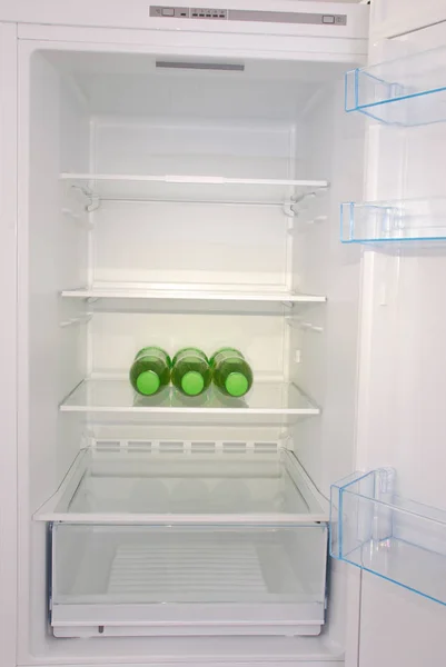Láhev šťávy uvnitř prázdné čisté chladničky — Stock fotografie
