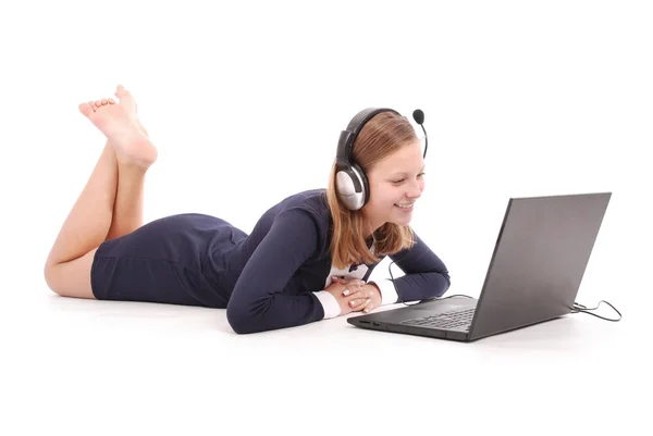 ノート パソコンとヘッドフォンを床に横になっているとかなり若い 10 代の少女 — ストック写真