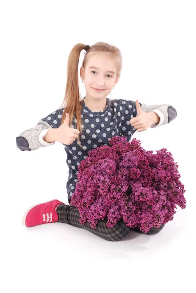 Menina atraente sentado no chão branco com lilás na mão — Fotografia de Stock