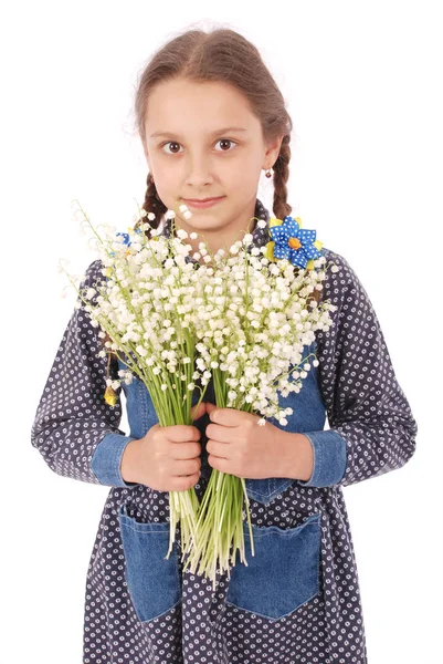 Retrato de una linda niña feliz sostiene una flor de un lirio del valle . — Foto de Stock