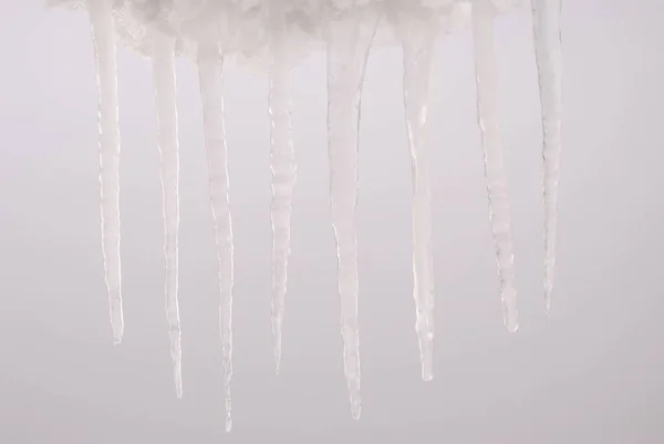 Eiszapfen isoliert auf einem grauen — Stockfoto