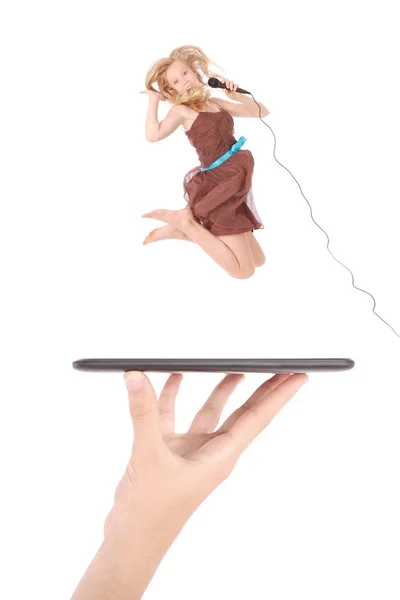 Jovem salto menina e cantando com microfone usando tablet pc na mão pessoas — Fotografia de Stock